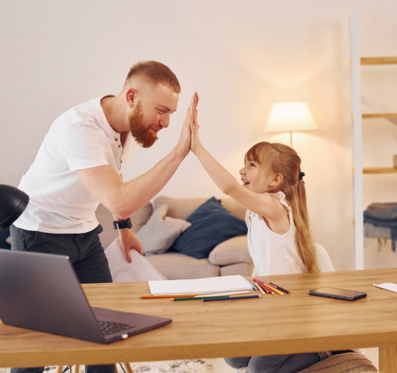 Cozy atmosphere. Father with his little daughter is at home together