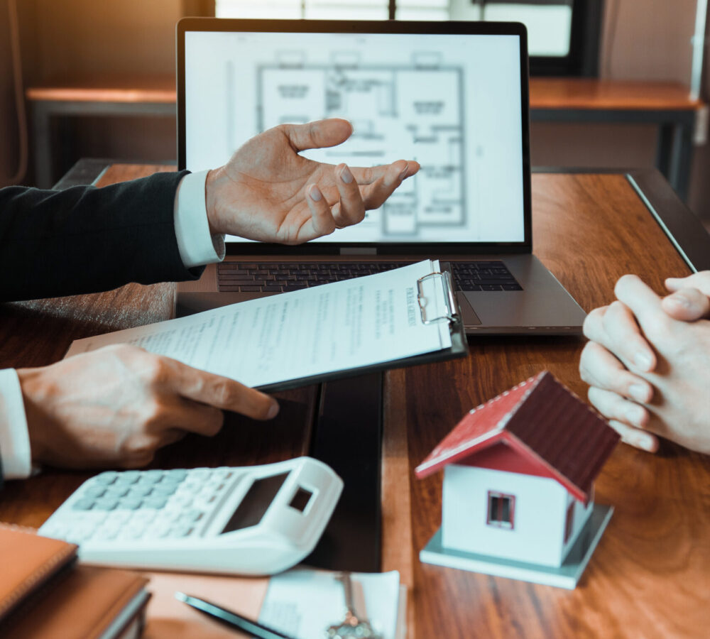 Insurance brokers are pointing to insurance contract signing and are explaining to customers at the office.